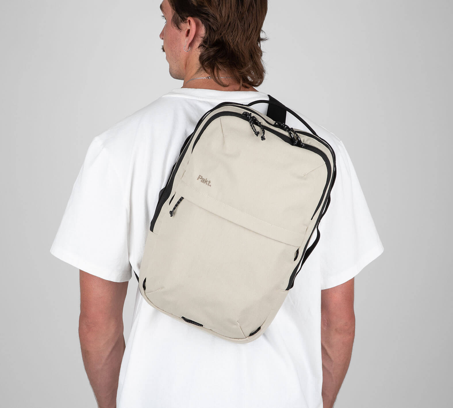 Man with tan sling backpack